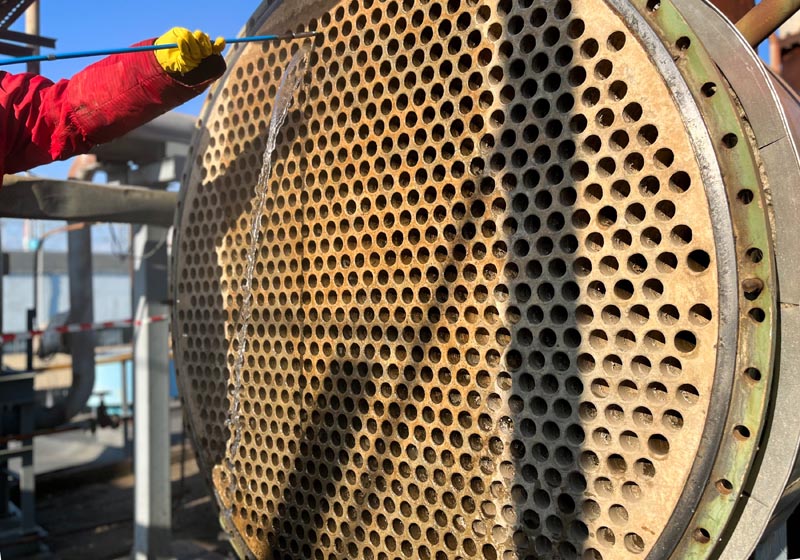 Cleaning a shell and tube heat exchanger with a high-pressure hydraulic unit
